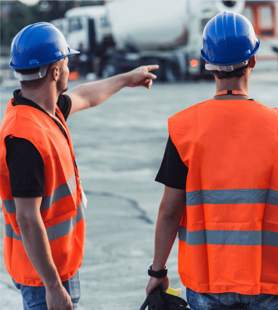 HazTek Inc. managers wearing orange vests and blue hard hats with one pointing to distant location.