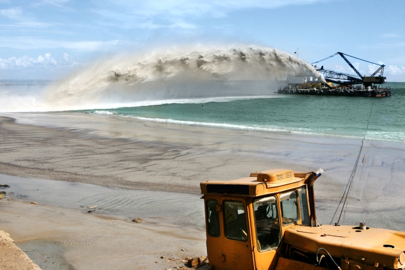 Dredging Marine Haztek Inc. - A focused site safety professional recording data using a pen and clipboard.