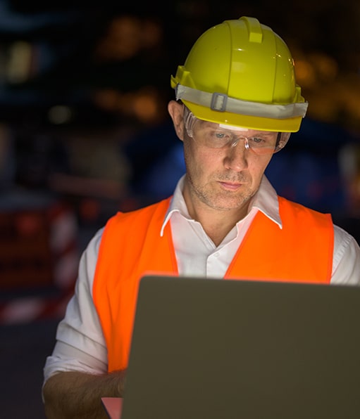 Haztek Inc. corporate safety management professional analyzing data on laptop.