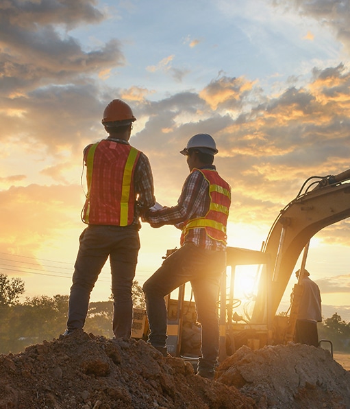 Two certified safety professionals working on location with sun on the horizon.